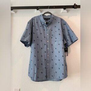 US Polo shirt, NWT. Blue chambray with navy polo emblems scattered on fabric.